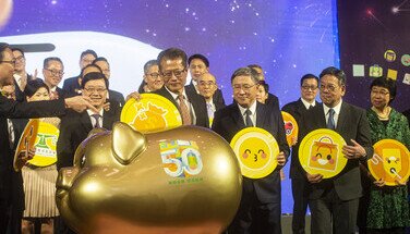 財政司司長陳茂波先生將大金幣放入寓意累積財富的金禧聚財幸運豬中，響應「精明消費 燃亮經濟」。